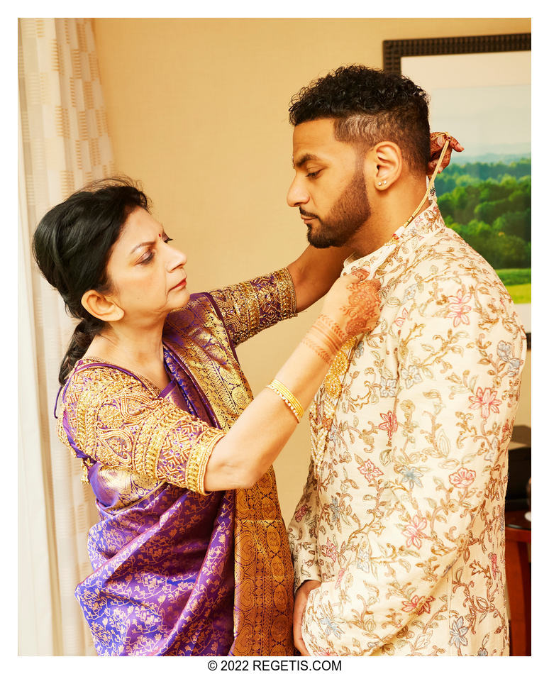 Mother of the groom adjusting the necklace on the groom.