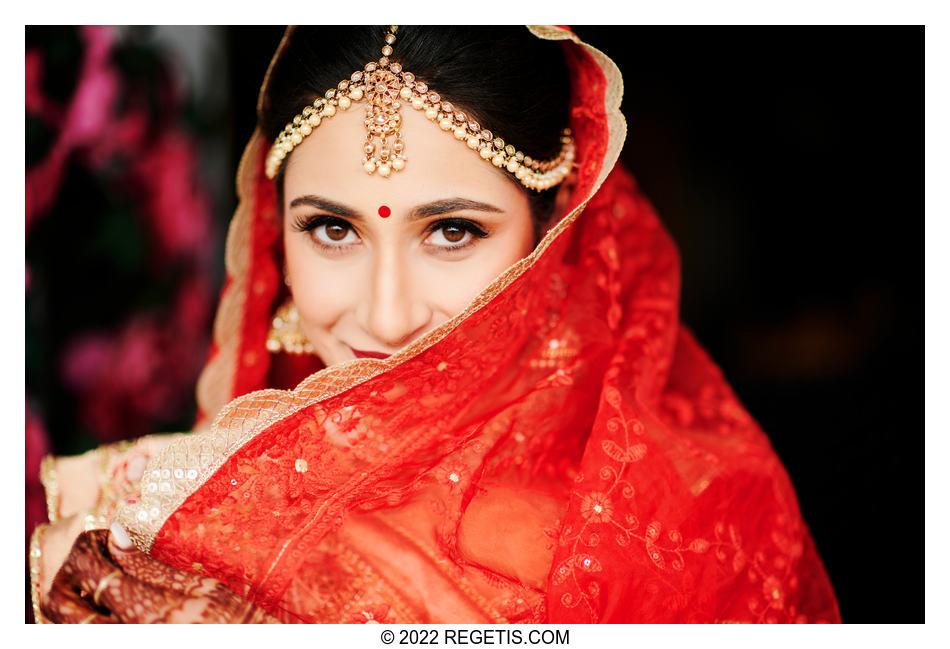 A stunning photo of Sonal behind her red wedding veil