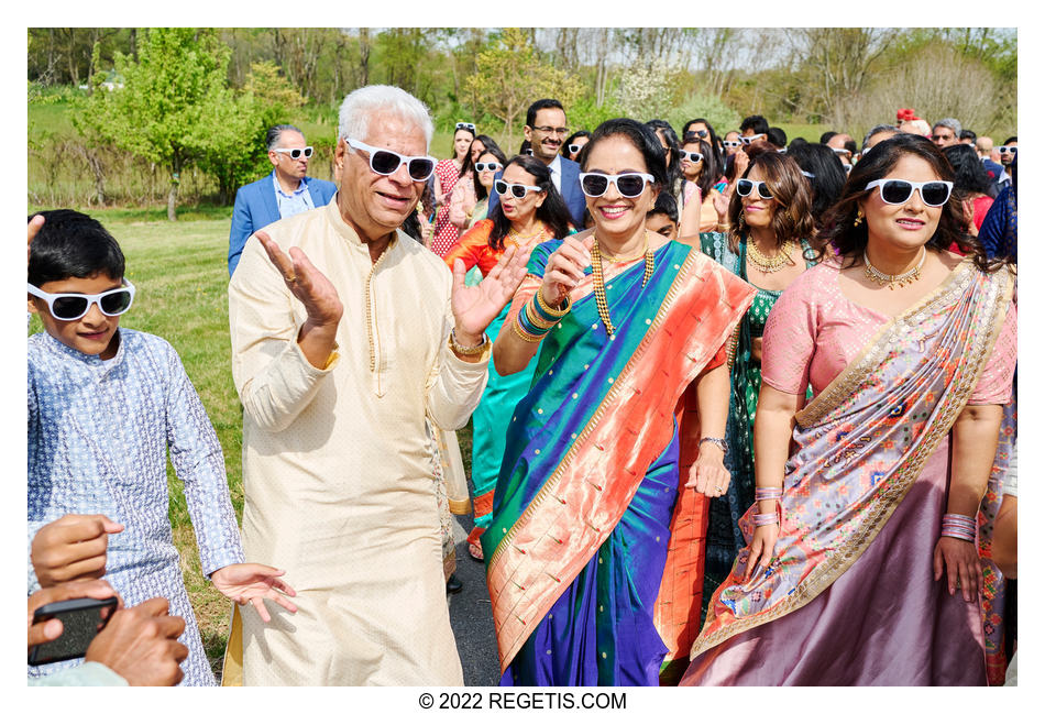 Father and mother of the groom dancing away at their son’s Indian wedding