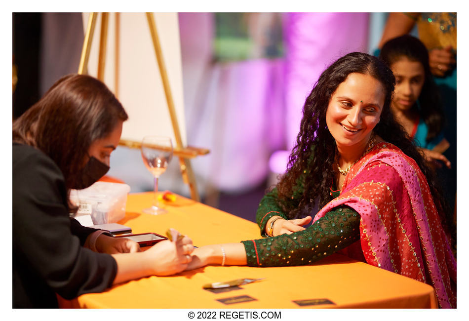 Guests getting mehendi done on her hands at Tripali and Nitin’s Sangeet ceremony at 101 Constitution AVE